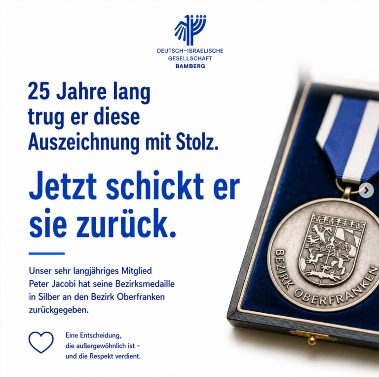 Peter Jacobi (DIG) gibt seine „Bezirksmedaille in Silber“ zurück.